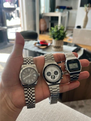 Tre stilrena klockor i silver - Säljer tre snygga klockor med metallarmband. En klassisk Casio digital med retrovibbar, en Timex kronograf med vit urtavla och svarta detaljer samt en stilren analog klocka med datumvisning. Alla har silverfärgat armband i rostfritt stål och passar perfekt till en modern look.