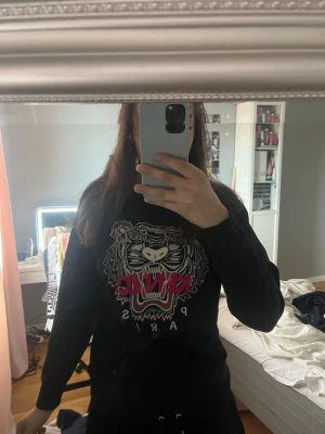 Svart Kenzo tröja  - Svart sweatshirt från Kenzo med ikoniskt tigertryck och texten framtill. Tröjan är långärmad, storleken är  S men jag skulle säga att den passar Xs-M. Om du har tankar eller funderingar är det bara att höra av dig! 