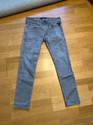 Ljusgråa slim fit jeans från Replay   - Säljer ett par ljusgråa slim fit jeans från Replay. Jeansen har klassisk femficksdesign, smal passform och dragkedjegylf. Perfekta för dig som gillar en stilren och modern look.