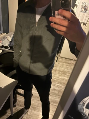 Sommar jacka  - Snygg oliv grön overshirt/ sommar jacka från Jack & Jones med dragkedja framtill och två bröstfickor. Overshirten har klassisk krage och är tillverkad i ett mjukt material som ger en avslappnad look. Perfekt att bära över en t-shirt.