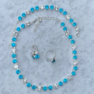 Smyckesset Aquamarine - Halsband, armband, örhängen och ring, med blandade kristaller. Silverpläterad mässing. Färg, Dark Aquamarine och Clear Crystal, ss39 8mm stora kristaller. Längd 45cm inkl lås och förlängningskedja.  Jag skickar endast spårbart, samfraktar. Fast pris. Besök gärna mina övriga annonser.  Till mina smycken använder jag kristaller från Preciosa, Aurora och Swarowski.