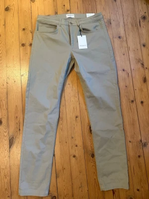 Beige chinos  These Glory Days - Snygga beige chinos från These Glory Days med rak passform och klassiska fickor både fram och bak. Tillverkade i ett mjukt bomullsmaterial som ger en clean och stilren look. Aldrig använda prislapp kvar på. Nypris 799