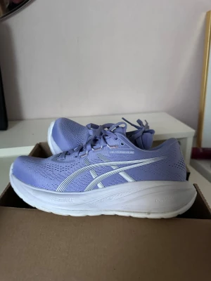 Lila Asics Gel-Cumulus 28 sneakers - Snygga lila Asics Gel-Cumulus 28 sneakers med vit sula och vita detaljer. Ovandelen är i ventilerande meshmaterial och skorna har klassisk snörning. Perfekta för dig som gillar sportig stil och vill ha bekväma sneakers med modern look. Endast använda en gång så finns lite smuts men annars verkligen i nyskick! 