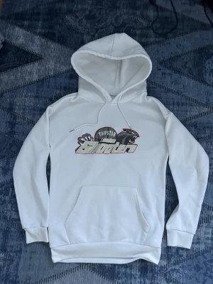 Vit Trapstar London Shooter hoodie - 98% polyester,Snygg vit hoodie från Trapstar med trycket 'London Shooter' och cool grafik på bröstet. Hoodien har huva med dragsko och en stor magficka framtill. Perfekt för dig som gillar streetwear och vill sticka ut med en unik design.