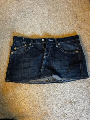 Mörk jeanskjol med broderade kronor - Kjol från Victoria Beckham, säljer för att den är för stor 