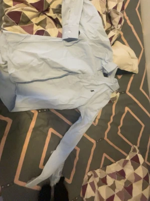 Ljusblå skjorta från Ralph Lauren - Klassisk ljusblå skjorta från Ralph Lauren med button-down krage och broderad logga på bröstet. Skjortan har lång ärm och knäppning framtill. Perfekt för en stilren look. Storlek S men passar även M aldrig använd 