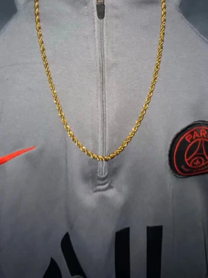 Guldfärgat kedjehalsband - Snyggt halsband i guldfärg med tvinnad kedja som ger en stilren och modern look. Perfekt accessoar för att lyfta din outfit och ge en extra touch av stil. Passar dig som gillar klassiska smycken med en trendig twist.