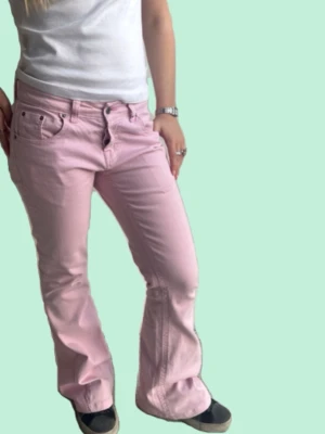 Ljusrosa bootcut jeans - Bootcut jeans med låg.  Midja: 38-39cm Innerbenslängd: 40cm