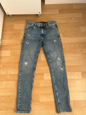 Blå slitna skinny jeans - Snygga blå skinny jeans med slitningar och hög midja. Jeansen har klassisk femficksdesign och dragkedja med knapp. Perfekta för en avslappnad och trendig look. Materialet är denim i bomull. Priset går att diskuteras