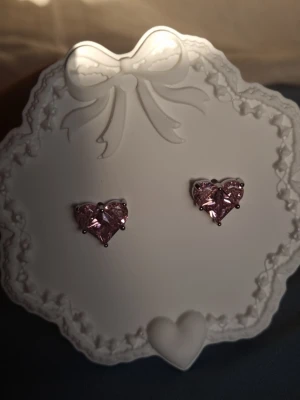 My First Love  - Vissa känslor glömmer man aldrig. My First Love studs är en hyllning till den första förälskelsen – skir, gnistrande och helt oförglömlig. De skapade för att vinna ditt hjärta om och om igen. Material: Rostfritt stål. Nickeltestat & allergivänligt       Ursprung : Thailand.                                 Storlek: ca 1 cm.                                -Levereras i en smyckespåse som på bilden.  -Inga prisförslag, tack                                       -Varan packas noggrant och säkert. 