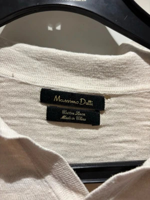 Beige pike från Massimo Dutti | strl M - Snygg vit  pike från Massimo Dutti i en blandning av bomull och linne. Skjortan har klassisk krage och en stilren look som passar perfekt till många outfits. Perfekt för dig som gillar en fräsch och enkel stil.
