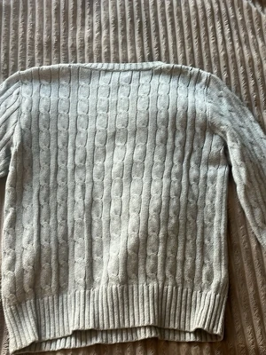 Ljusgrå kabelstickad tröja Polo Ralph Lauren - Kabelstickad tröja i ljusgrått från Polo Ralph Lauren. Klassisk modell med rund halsringning, ribbade muddar och nederkant. Liten broderad logga på bröstet. Perfekt för lager på lager och enkel att matcha.