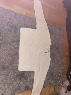 Vit stickad tröja från Kappahl - Säljer en enkel och stilren vit stickad tröja från Kappahl. Tröjan har rund halsringning, långa ärmar och är ribbstickad för en mjuk och bekväm känsla. Perfekt att matcha med jeans eller kjol för en clean look. Helt ny! 🥰
