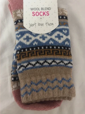 Mönstrade ullblandade strumpor - Ullblandade strumpor med klassiskt mönster i beige, blått, vitt och brunt. Strumporna har en mjuk och varm känsla, perfekta för kyligare dagar. Snyggt mönster som ger en retrovibe och passar till många stilar.