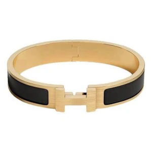 H-armband - Snyggt armband från H i guldtonad metall med svart emalj. Armbandet har en stilren och modern design med det ikoniska H-spännet framtill. Perfekt accessoar för att lyfta vilken outfit som helst. (Tunnt band) Obs! Köptes i Grekland, inte äkta!