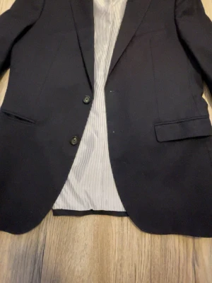 Marinblå kavaj Tommy Hilfiger Slim Fit - Snygg marinblå kavaj från Tommy Hilfiger i modellen TH Flex Slim Fi.           Ord.pris-4000-5000 kr pris kan diskuteras