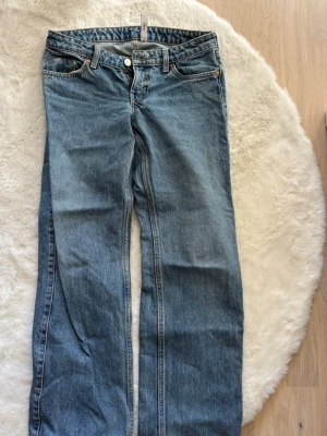 Blå raka jeans från Weekday - Klassiska blå jeans från Weekday med rak passform och fem fickor. Jeansen har normal midja, knappgylf och är tillverkade i slitstark denim. Perfekta för en avslappnad och tidlös stil. Köpta på Sellpy för något år sedan men har sedan dess vuxit ur dem, men jättefina o bra kvalité! 