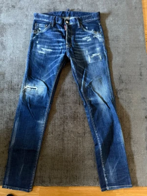 Blå slitna jeans från Dsquared2 - Säljer ett par blå jeans från Dsquared2, mycket bra skick. Köpta från Farfetch.