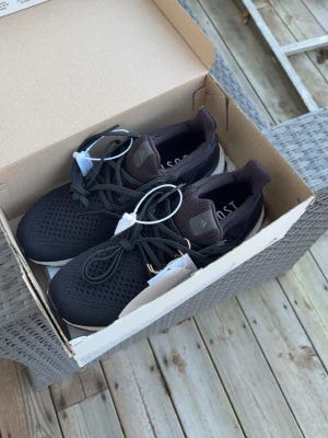 Svarta Adidas Ultra Boost sneakers - Snygga svarta Adidas Ultra Boost sneakers med stickad ovandel och vita Boost-sulor. Skorna har en låg profil och klassisk snörning. Yttersulan är i slitstarkt gummi med Continental-mönster för extra grepp. Perfekta för dig som gillar streetwear och sportig stil. HELT NYA OANVÄND