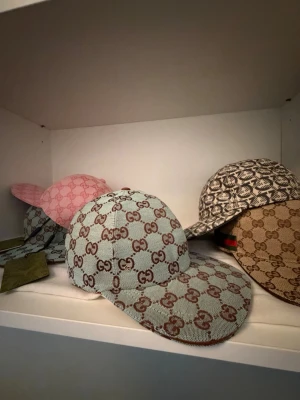 Gucci GG monogram keps ljusblå - Säljer en snygg keps från Gucci i ljusblått tyg med det klassiska GG-monogrammet i brunt över hela kepsen. Kepsen har böjd skärm och justerbar rem bak. Perfekt för dig som vill ha en statement-accessoar med lyxig känsla.