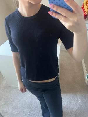 Svart kortärmad topp i bomull - En enkel och stilren svart topp med rund hals och korta ärmar. Toppen har en rak passform och är gjord i mjuk bomull, perfekt till jeans eller kjol. Snygg och basic för alla tillfällen.