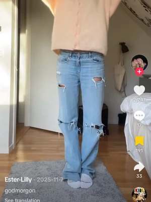 Ljusblå slitna bootcut jeans - Säljer ett par ljusblå bootcut jeans med stora slitningar vid knäna och råa kanter. Jeansen har en klassisk femficksmodell och är tillverkade i denim med lite stretch. Perfekta för en avslappnad och trendig look.