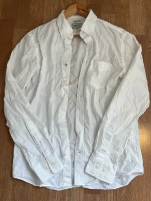 Vit skjorta från Boomerang, S - Klassisk vit skjorta från Boomerang i 100% ekologisk bomull. Skjortan har regular fit, lång ärm, bröstficka och knappar framtill. Perfekt basplagg med tidlös design och mjukt material. Inga defekter. Tveka inte på att höra av dig ifall du undrar något!✨