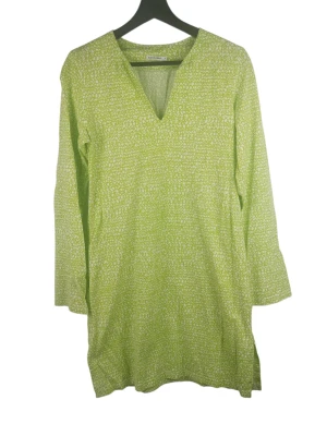 Marimekko Nyöri Lanka grön klänning v-ring, storlek Small - En grön och vit klänning med långa ärmar och V-ringning. Klänningen har ett mönster av sammanflätade linjer över hela plagget. Det finns små slitsar i sidorna nertill. Armhåla till armhåla: 43cm Axelbredd: 39cm Långt: 88cm Armlängden från armhåla: 47cm