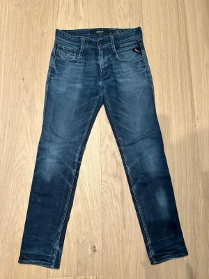Replay ANBASS blå slim fit jeans - Snygga blå slim fit jeans från Replay. Jeansen har normal midja, dragkedjegylf och Replay-logga på fickan. Perfekta för en avslappnad och trendig look.