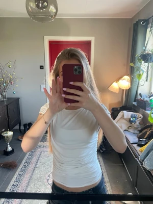 Vit tight t-shirt med rund hals - Säljer en enkel och stilren vit t-shirt med rund hals och korta ärmar. Väldigt luftig och sitter inte så tight. Knappt använd. Skriv om ni har frågor 