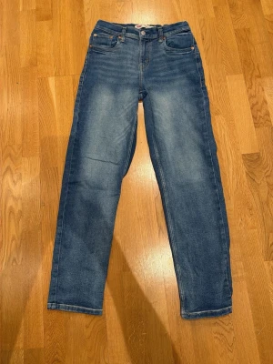 Levi's Loose Taper jeans blå - Säljer ett par blå Levi's Loose Taper jeans med klassisk femficksdesign och avsmalnande ben. Jeansen har en snygg tvättad look och är perfekta för en avslappnad stil. Passar dig som gillar bekväma och trendiga jeans.