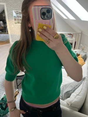 Grön croppad topp med kort ärm - Snygg grön croppad topp med korta ärmar och rund hals. Enkel och stilren design utan mönster eller detaljer, perfekt att matcha med jeans eller kjol. Vet inte vad det är för storlek men passar mig som är S/M