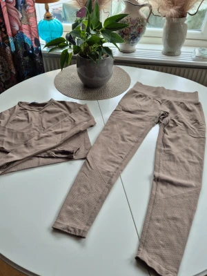 Träningsset * Brunrosa * stl M - Träningsset i två delar bestående av en långärmad topp och matchande leggings. * Stl M (normal i stl enlig mig) * Färgen är en snygg brunrosa ton. Svårt att fånga den.  Djur och rökfritt hem. Se bilder och förstora då de ingår i beskrivningen. Se gärna mina övriga annonser. 