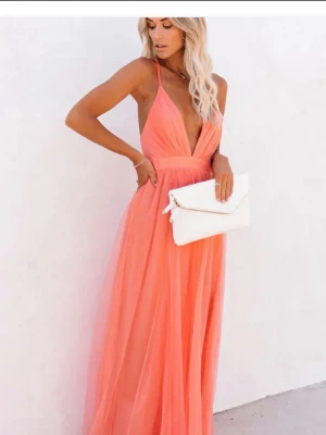 Korall balklänning  - Säljer denna jättefina korall  orangea balklänningen då den var lite för stor för mig i bysten. Jag är 175 cm och annars att den väldigt bra i längd osv. Väldigt lätt och skönt material! Endast testad. Byst tvärsöver ca 40 cm  Längd från axelband till slutet av klänningen 140 cm Har tyvärr inga bilder på då den är för stor i bysten som sagt. 