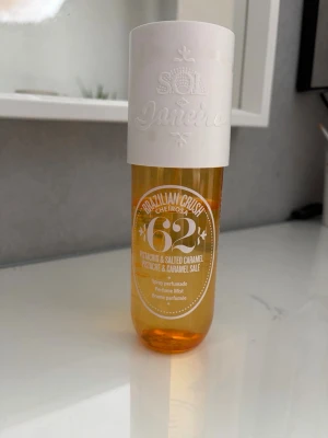 Sol de Janeiro Cheirosa 62 Parfymmist - Fräsch och söt doftmist från Sol de Janeiro, Brazilian Crush Cheirosa 62. Flaskan är genomskinlig med gul-orange ton och har ett vitt lock. Doften har inslag av pistage och salt karamell. Perfekt för dig som vill ha en unik och somrig parfym.