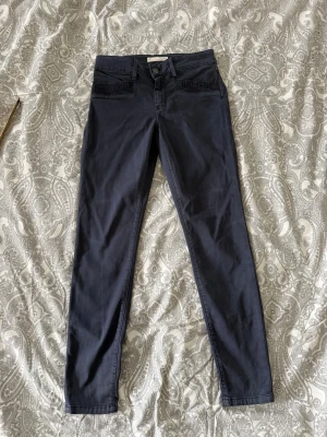 Svarta skinny jeans med spetsdetalj odd Molly  - Snygga svarta skinny jeans med spetsdetalj vid fickorna framtill. Jeansen har klassisk femficksmodell och smal passform hela vägen ner. Perfekta för dig som gillar en stilren look med en twist. märke Odd Molly 
