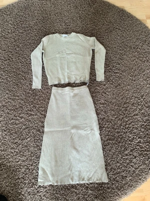 Beige ribbat set från Vila - Säljer ett snyggt tvådelat set från Vila i beige ribbat material. Setet består av en långärmad topp med rund hals och en matchande lång kjol. Perfekt för dig som gillar en enkel men trendig look. Materialet är mjukt och stretchigt för extra komfort.