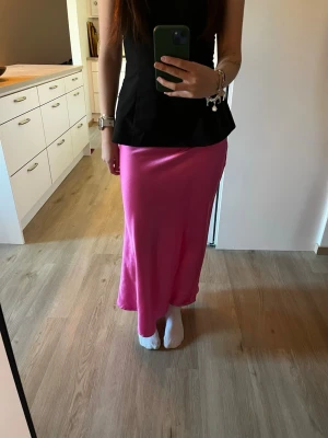 Rosa långkjol i satin från NA-KD - Säljer en snygg rosa långkjol från NA-KD i glansigt satinmaterial. Helt oanvänd🫶🏼🫶🏼