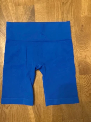 Blå cykelshorts från Primark - Snygga blå cykelshorts från Primark med hög midja och stretchigt material. Perfekta för en sportig look eller att bara chilla i. Mjuka och bekväma med en tight passform som sitter på plats hela dagen.