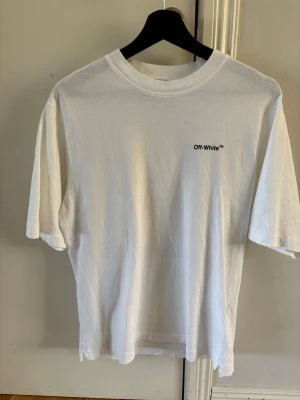 Off White T shirt - Off-white t-shirt med tryck från höst-vinterkollektionen 2022-2023 i gott skick. Levereras med originaletiketter. Köpt på Bergdorf Goodman i New York.  Tveka inte att höra av dig om du har några frågor!