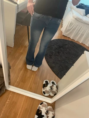 Ljusblå bootcut jeans - Säljer ett par ljusblå bootcut jeans med klassisk femficksdesign och lite blekningar fram och bak. Jeansen har normal midja och utsvängda ben, perfekta för en avslappnad och trendig look. Materialet är mjukt denim som sitter bekvämt hela dagen.