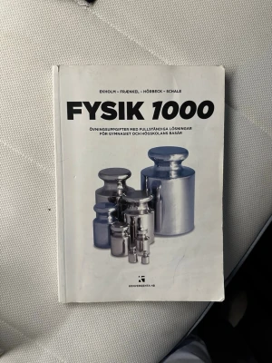 Fysik 1000 övningsuppgifter bok - Fysik 1000 är en vit kursbok med svart text och bild på vikter i metall. Boken innehåller övningsuppgifter med fullständiga lösningar för gymnasiet och högskolans basår. Perfekt för dig som pluggar fysik och vill ha extra träning.