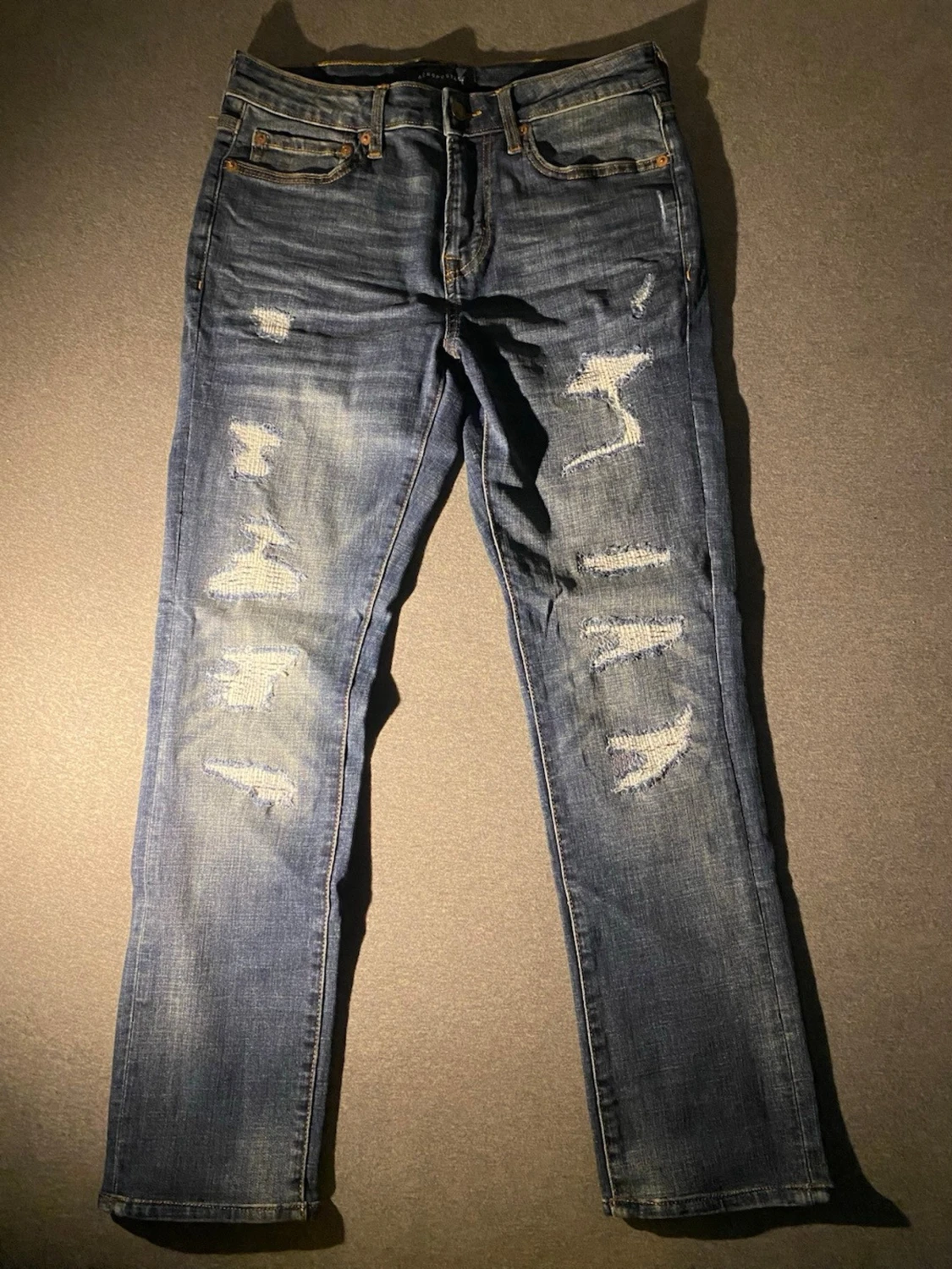 Blå slitna jeans med raka ben