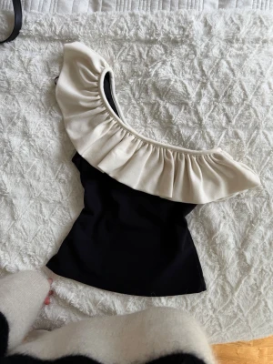 Svart one shoulder topp med volang - Jättesnygg 
