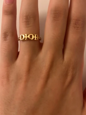 Guldfärgad ring med pärldetaljer - Säljer en snygg guldfärgad ring. Ringen har små pärldetaljer längs bandet som ger en lyxig känsla. Perfekt accessoar för dig som gillar statement-smycken och exklusiv design.