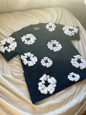 Svart t-shirt med vita blommor - Tjena! Rensar sonens garderob och vill bara bli av med skiten så vet ej hur mycket de är värt utan går på magkänsla. 