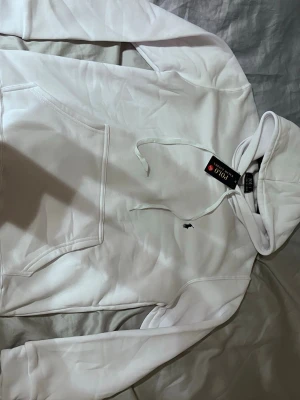 Vit hoodie från Polo Ralph Lauren - Snygg vit hoodie från Polo Ralph Lauren med klassisk huva och dragsko. Har en känguruficka framtill och den ikoniska lilla broderade loggan på bröstet. Perfekt för en clean och stilren look och vid snabbt köp endast 400kr.