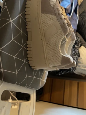 Vita sneakers med platåsula - Stilrena vita sneakers med chunky platåsula och detaljer i mockaimitation. Ovandelen är i mesh och syntetmaterial för en fräsch look. Skorna har klassisk snörning och en modern, sportig vibe som passar till många outfits.