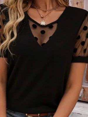 Svart topp med mesh och prickar - Trendig svart topp med transparent mesh och stora svarta prickar på ärmar och vid halsringningen. V-ringad design och korta ärmar ger en modern look. Perfekt för dig som vill sticka ut lite extra.