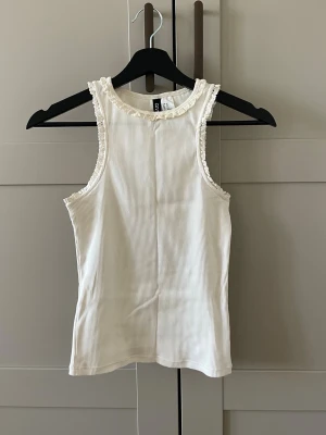 Vit ribbat linne med spetskant - Jättefint creme vitt linne med spetskant upptill.